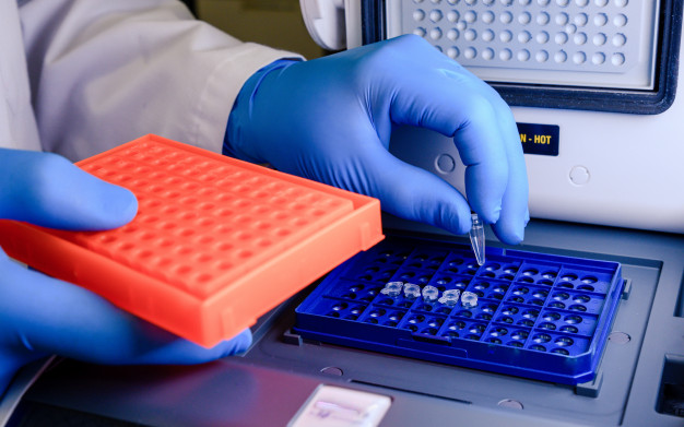 trabajador-laboratorio-colocando-puntas-pipeta-recipiente-azul-prueba-coronavirus_181624-927